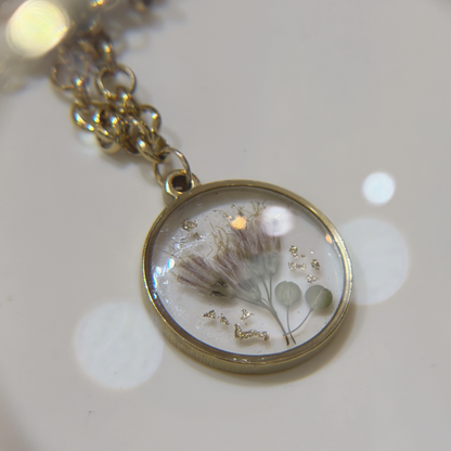 Resin necklace with pressed natural flowers and gold leaf, handmade at a botanical jewellery workshop in Barcelona