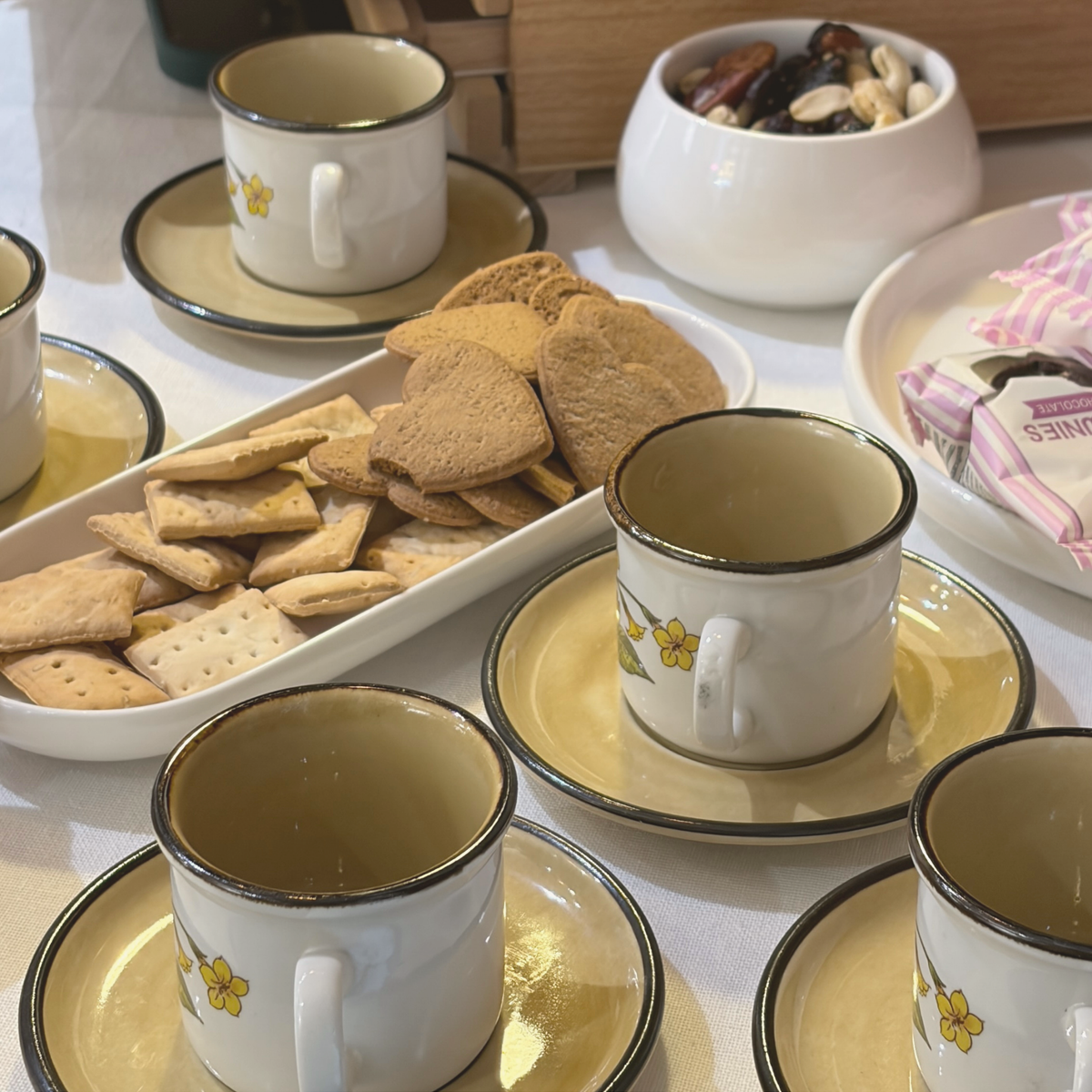 Tea and biscuits in cups with painted flowers, the break during the botanical jewellery workshop at MolaMon, Barcelona